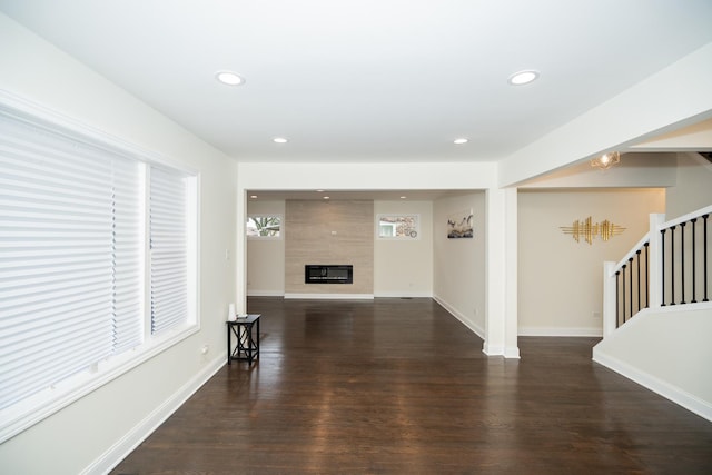 unfurnished living room with recessed lighting, a fireplace, wood finished floors, baseboards, and stairs