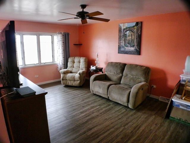 living room with dark wood-style floors, baseboards, and a ceiling fan