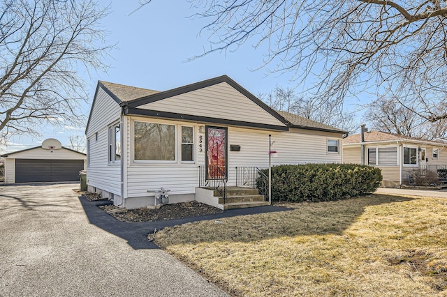 bungalow with a detached garage and an outbuilding