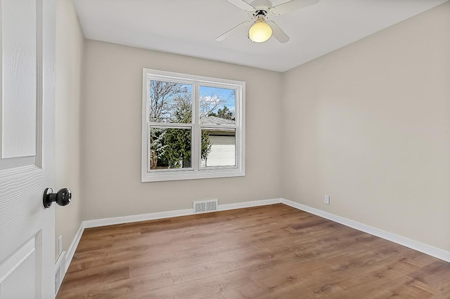 unfurnished room featuring ceiling fan, visible vents, baseboards, and wood finished floors