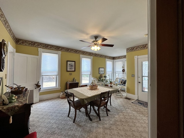 dining space with carpet, plenty of natural light, baseboards, and ceiling fan