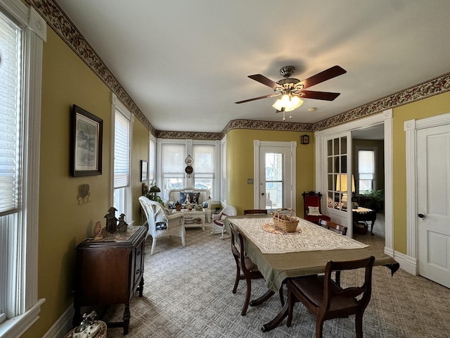 dining room featuring baseboards, a ceiling fan, and carpet flooring