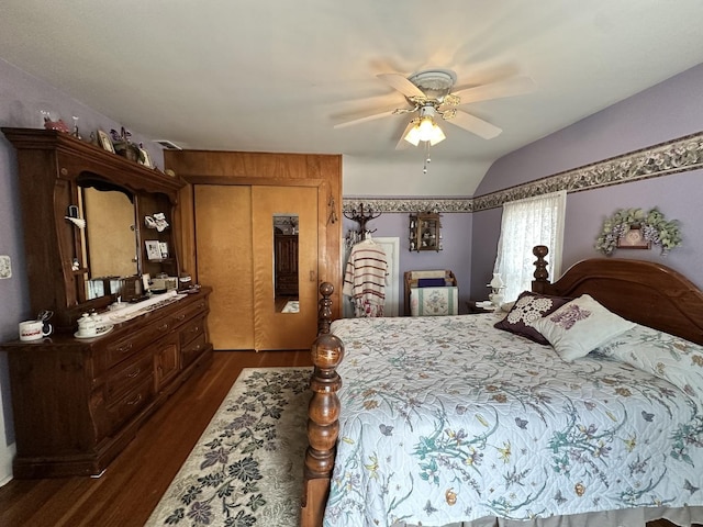 bedroom featuring dark wood-style floors, lofted ceiling, a closet, and a ceiling fan