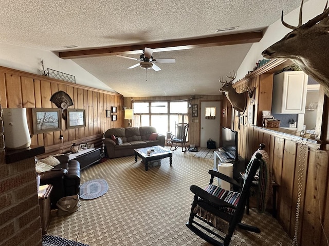 living area featuring vaulted ceiling with beams, visible vents, carpet flooring, wood walls, and a textured ceiling