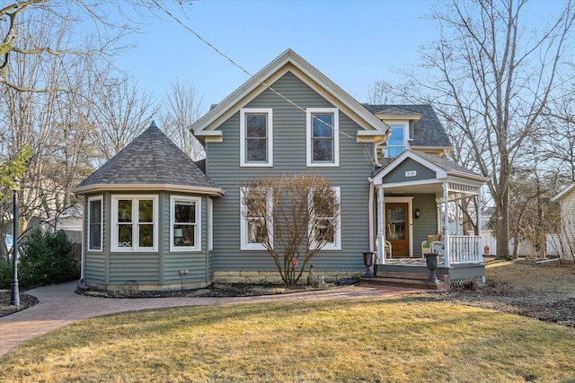 view of front of home with a front lawn, a porch, and a shingled roof