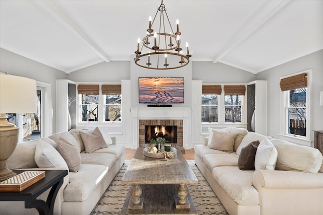 living room featuring vaulted ceiling with beams, a brick fireplace, plenty of natural light, and wood finished floors