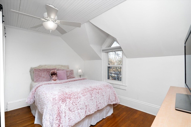 bedroom featuring lofted ceiling, baseboards, and wood finished floors