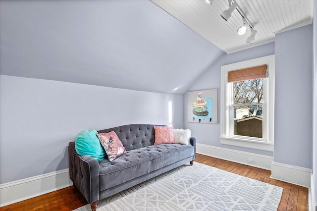 living room with vaulted ceiling, hardwood / wood-style floors, rail lighting, and baseboards