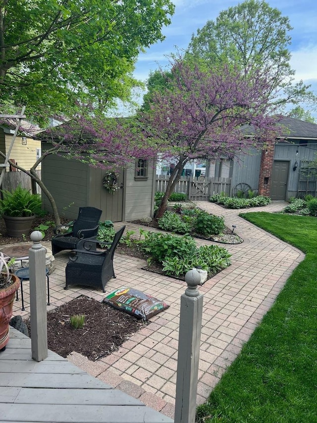 view of patio with an outbuilding and fence