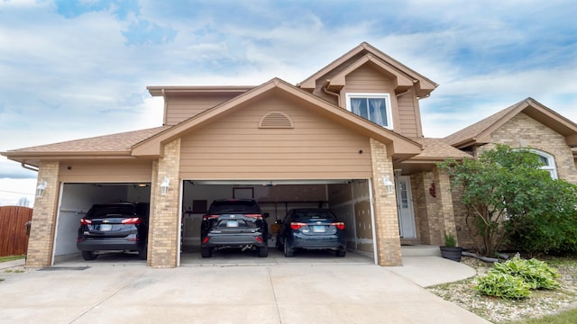 view of front of house featuring brick siding, driveway, an attached garage, and roof with shingles