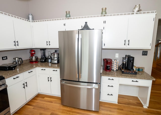 kitchen with light wood finished floors, white cabinetry, and stainless steel appliances