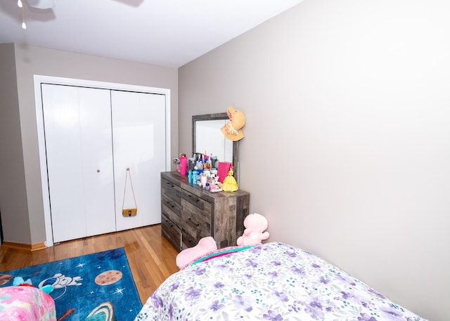 bedroom with ceiling fan, a closet, and wood finished floors