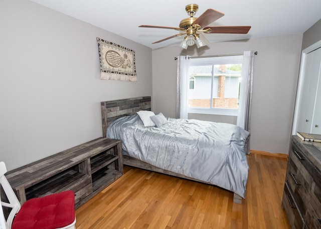 bedroom featuring ceiling fan, baseboards, and light wood-style floors