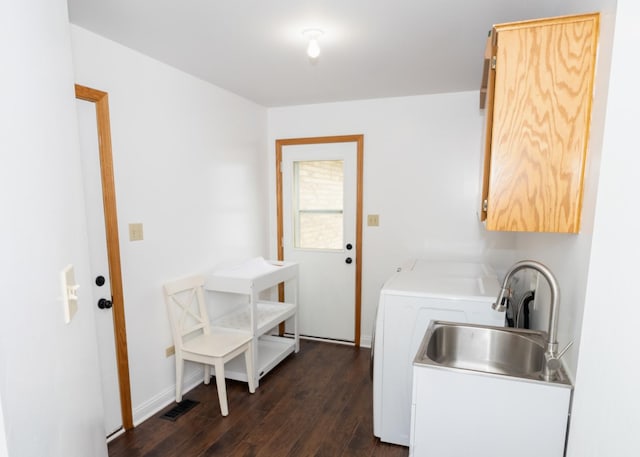 laundry room with cabinet space, visible vents, dark wood finished floors, washer / clothes dryer, and a sink