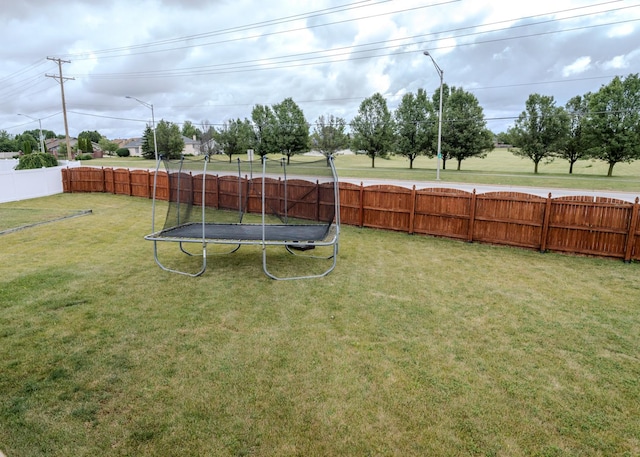 view of yard with a fenced backyard and a trampoline