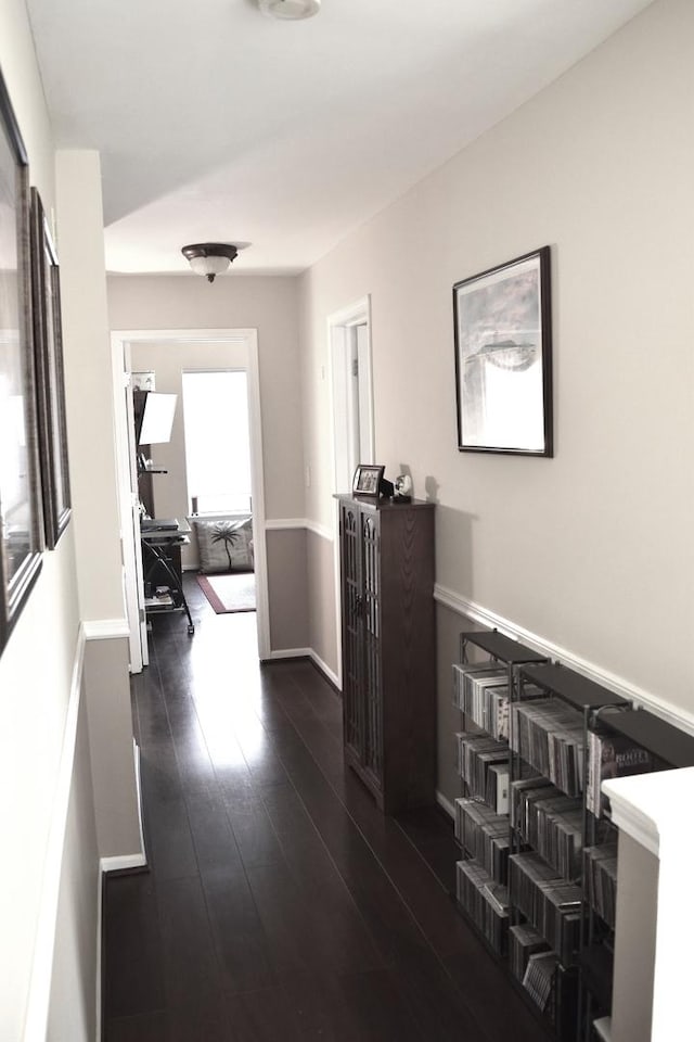 hall with dark wood finished floors and baseboards