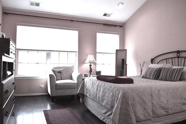 bedroom featuring visible vents, dark wood-type flooring, and vaulted ceiling