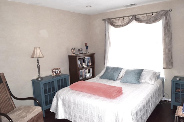 bedroom featuring visible vents, multiple windows, and wood finished floors