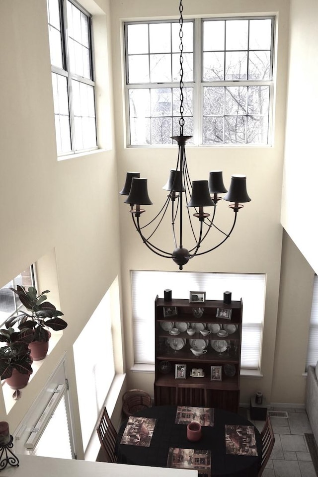 dining area featuring a notable chandelier and a towering ceiling