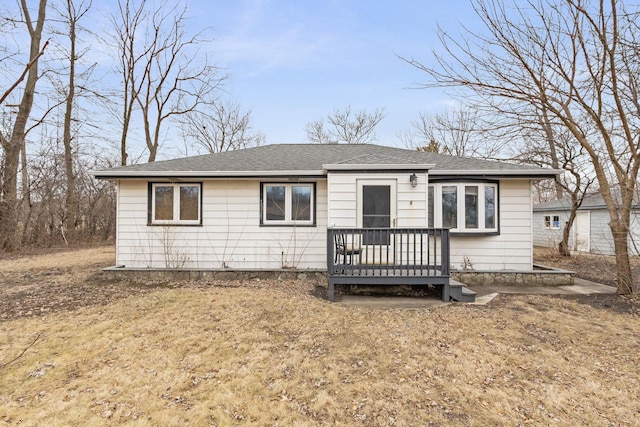 view of front of home featuring a deck and roof with shingles