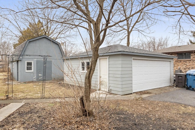 exterior space with an outbuilding, a gambrel roof, and a garage