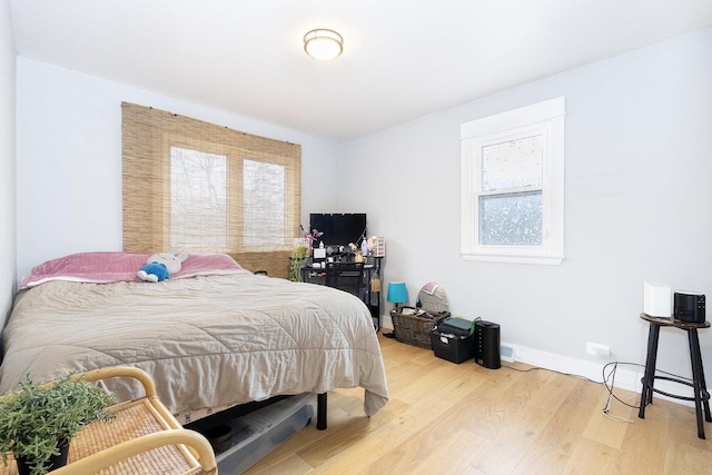 bedroom with baseboards and wood finished floors