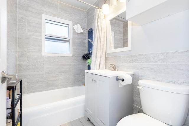 bathroom with toilet, shower / bath combo with shower curtain, tile walls, and vanity