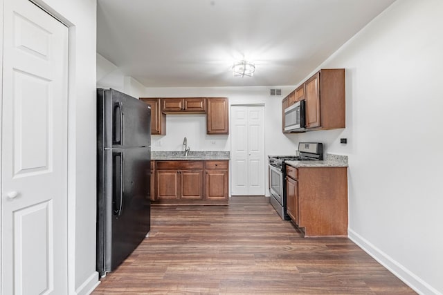 kitchen with brown cabinets, dark wood-style floors, and stainless steel appliances