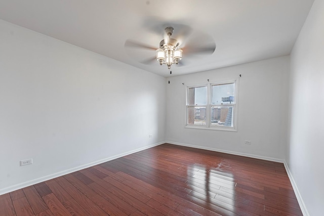 spare room featuring dark wood-style floors, ceiling fan, and baseboards