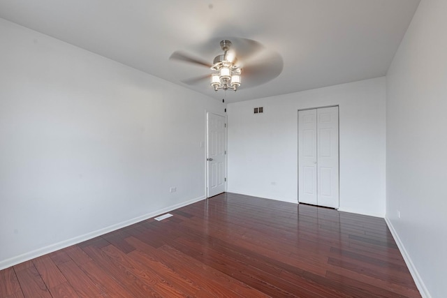 unfurnished bedroom featuring a closet, wood finished floors, a ceiling fan, and baseboards