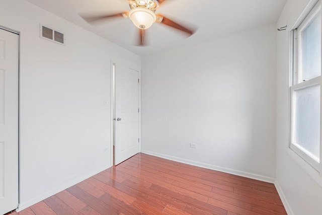 unfurnished room featuring visible vents, ceiling fan, baseboards, and wood finished floors