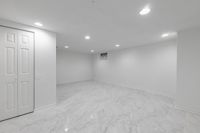 finished below grade area with recessed lighting, marble finish floor, and baseboards