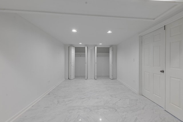 interior space with baseboards, marble finish floor, and multiple closets