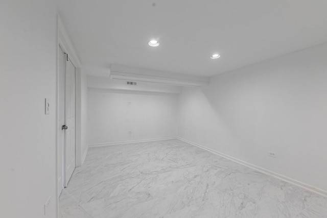 unfurnished room with recessed lighting, marble finish floor, visible vents, and baseboards