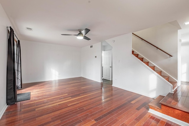 unfurnished living room with ceiling fan, stairs, visible vents, and hardwood / wood-style floors