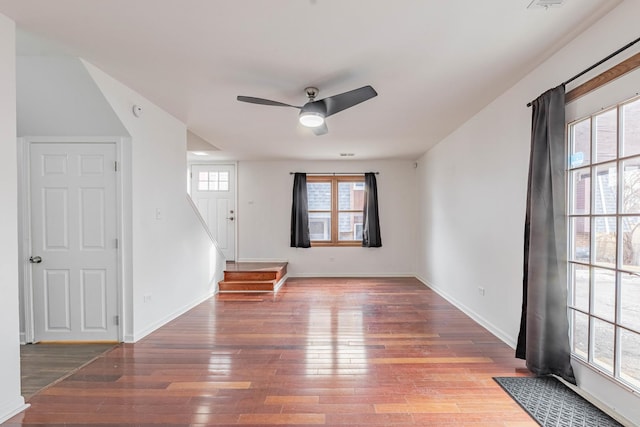 interior space featuring a ceiling fan, baseboards, stairway, and hardwood / wood-style floors