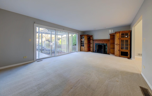 unfurnished living room featuring baseboards, a fireplace, visible vents, and carpet flooring