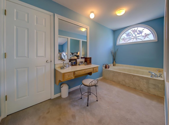 full bath featuring a garden tub and baseboards