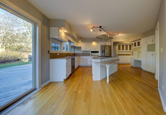 kitchen featuring stainless steel appliances, a sink, visible vents, white cabinetry, and light wood finished floors