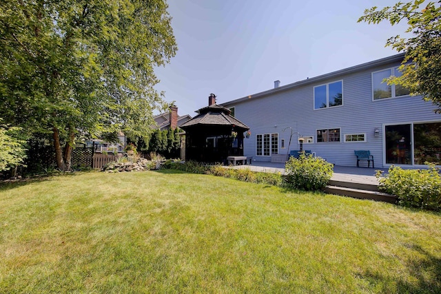 back of house featuring a deck and a lawn