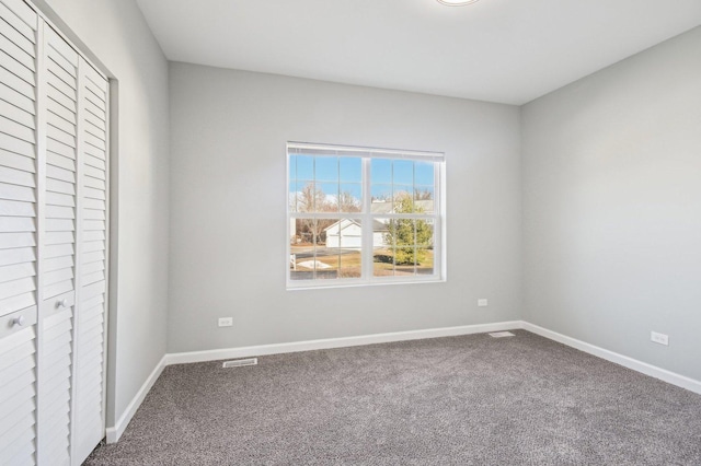 unfurnished bedroom featuring carpet floors, visible vents, and baseboards