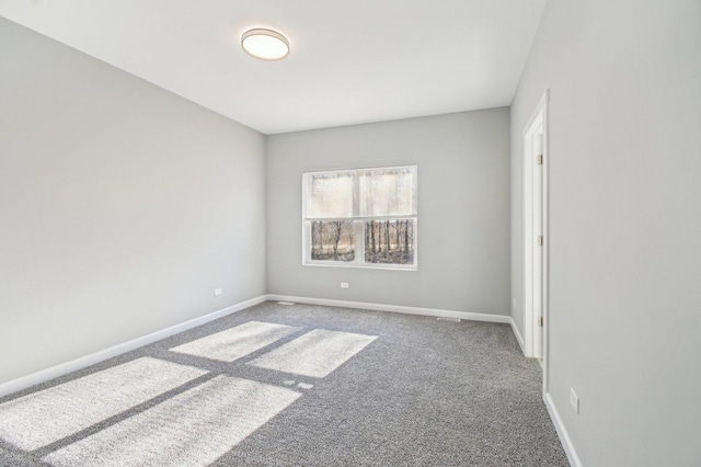 carpeted empty room featuring baseboards