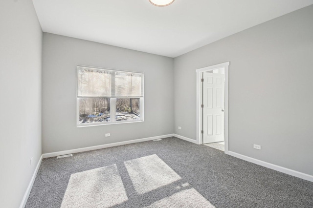 unfurnished room featuring carpet floors and baseboards