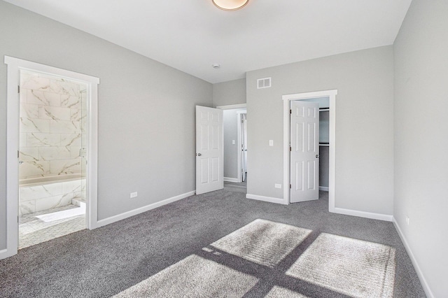 unfurnished bedroom featuring baseboards, visible vents, a walk in closet, and carpet flooring