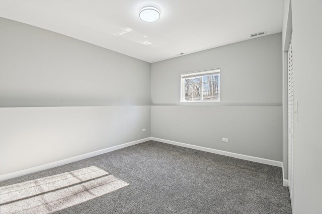 empty room featuring carpet flooring, visible vents, and baseboards