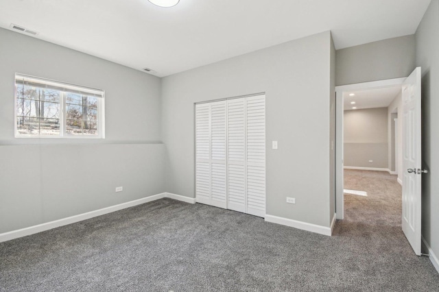 unfurnished bedroom with carpet floors, baseboards, visible vents, and a closet