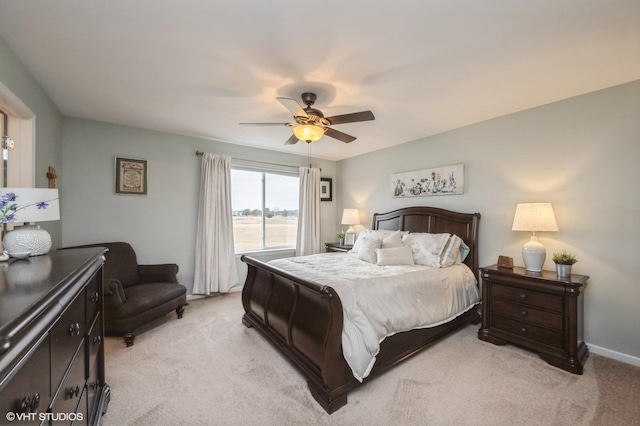 bedroom featuring a ceiling fan, light colored carpet, and baseboards