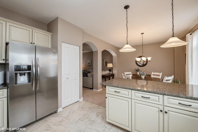 kitchen featuring arched walkways, a chandelier, marble finish floor, stainless steel refrigerator with ice dispenser, and pendant lighting