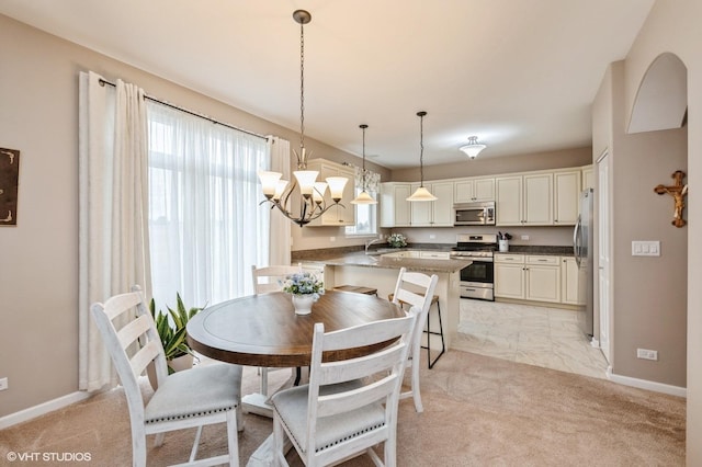 dining space with baseboards, a chandelier, and light colored carpet