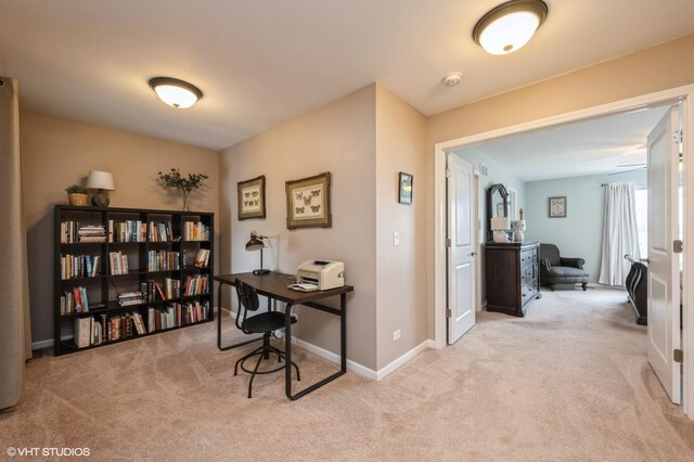 office area featuring light carpet and baseboards